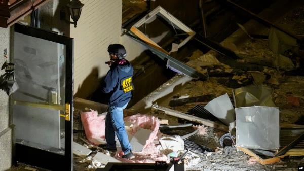 An official surveys an area near the back entrance to the Sandman Signature hotel following an explosion, Jan. 8, 2024, in Fort Worth, Texas.
