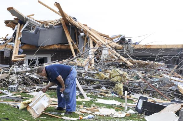 龙卷风袭击内布拉斯加州和爱荷华州部分地区后，居民们开始在废墟中搜寻